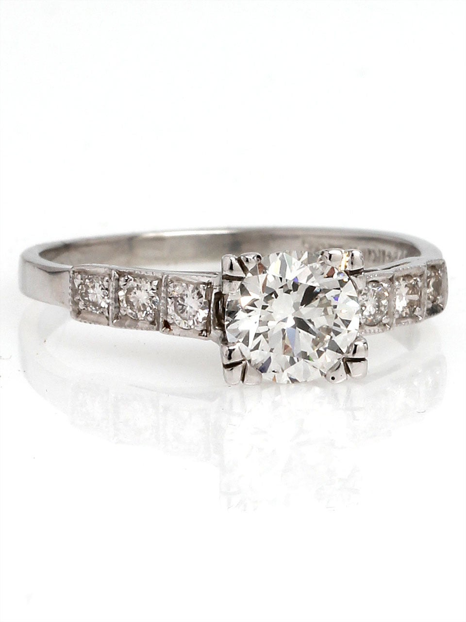 This lovely diamond platinum engagement ring dates from the 1930's and features an EGL lab certified 0.77ct full cut round brilliant diamond rated F colorless/SI1. This stunningly bright center stone is framed by a classic Art Deco stair step design