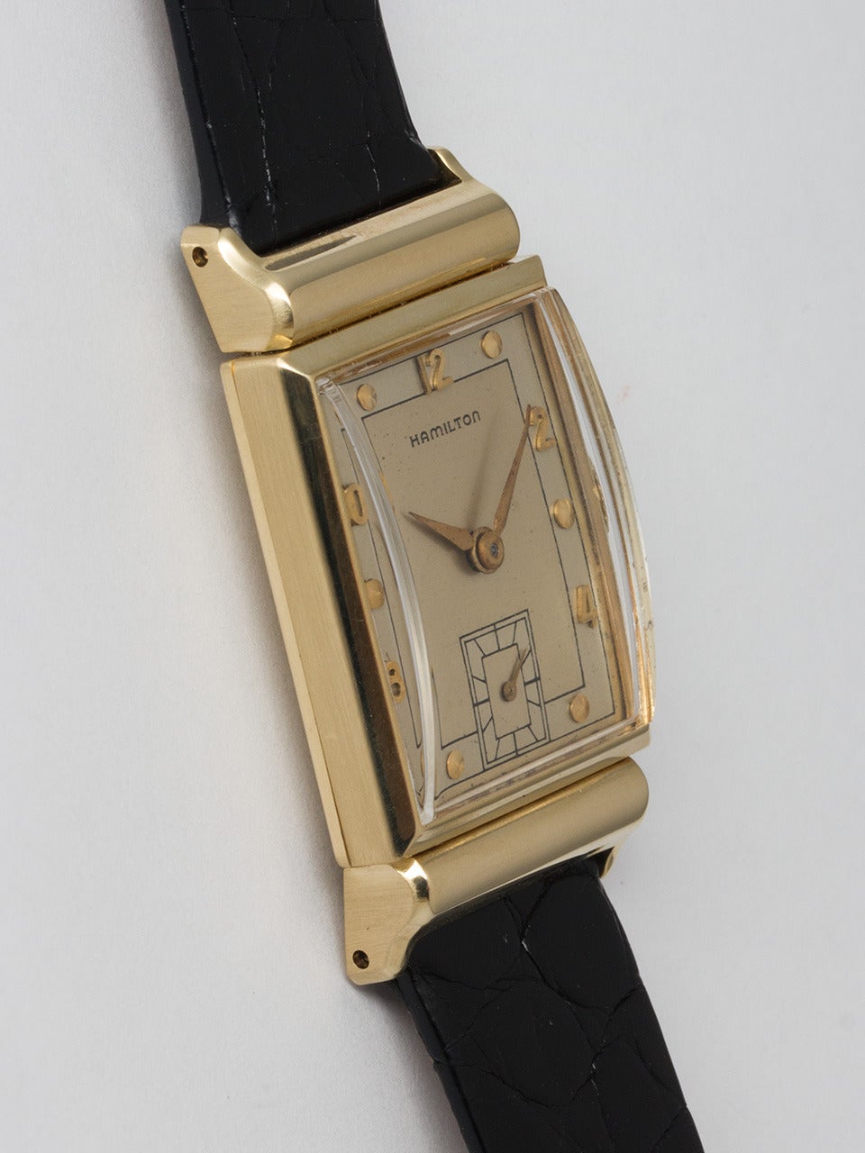 Hamilton 14K Yellow Gold Gordon Wristwatch, circa 1949. Featuring a 23 x 39.5mm rectangular case with hooded lugs. Original 2 tone silvered satin dial with raised yellow gold dots and numerals. Powered by Hamilton 982 caliber manual wind movement