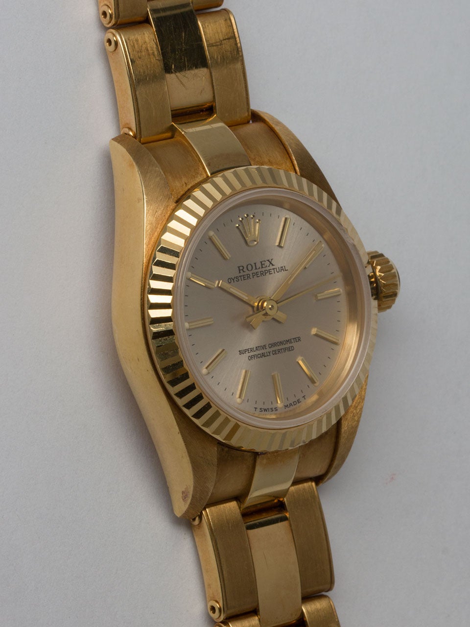 Rolex 18K Yellow Gold Lady's Oyster Perpetual Wristwatch ref 67198 serial #T3 circa 1996. 27mm diameter case with smooth bezel and sapphire crystal. Original silvered satin dial with applied gold indexes and gilt baton hands. Powered by self winding