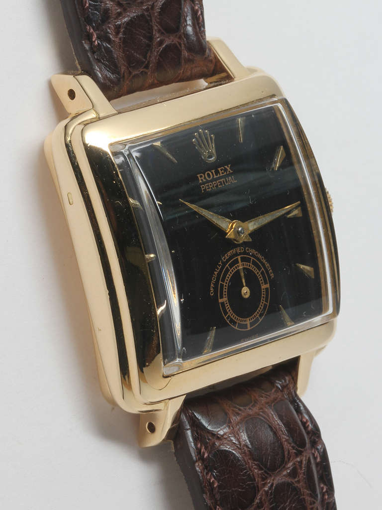 Rolex 18k yellow gold square automatic wristwatch, circa 1950s. A so-called Square Bubbleback model. 30.5 x 38.5mm case, thick with stepped bezel and semi-curved snap back. Glossy black dial with applied gold indexes and gold dauphine hands. Powered