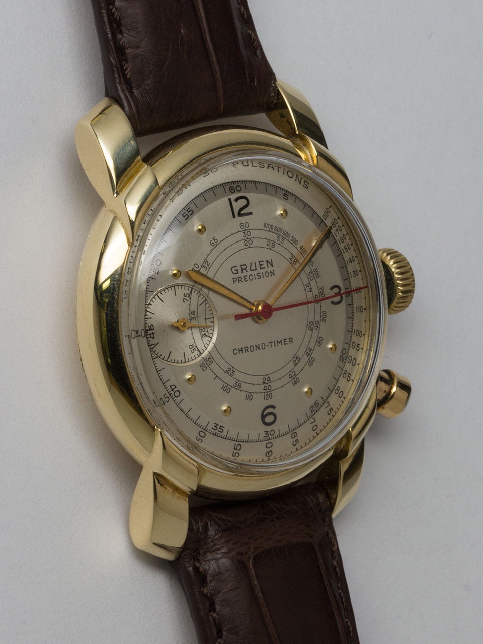 Gruen 14K Yellow Gold Chrono-Timer Wristwatch circa 1940s. Scarce and gorgeous model, 33 X 41mm case with wide contoured lugs and single round chronograph pusher at 4 o'clock. Mint condition original silvered satin dial with gold raised indexes and