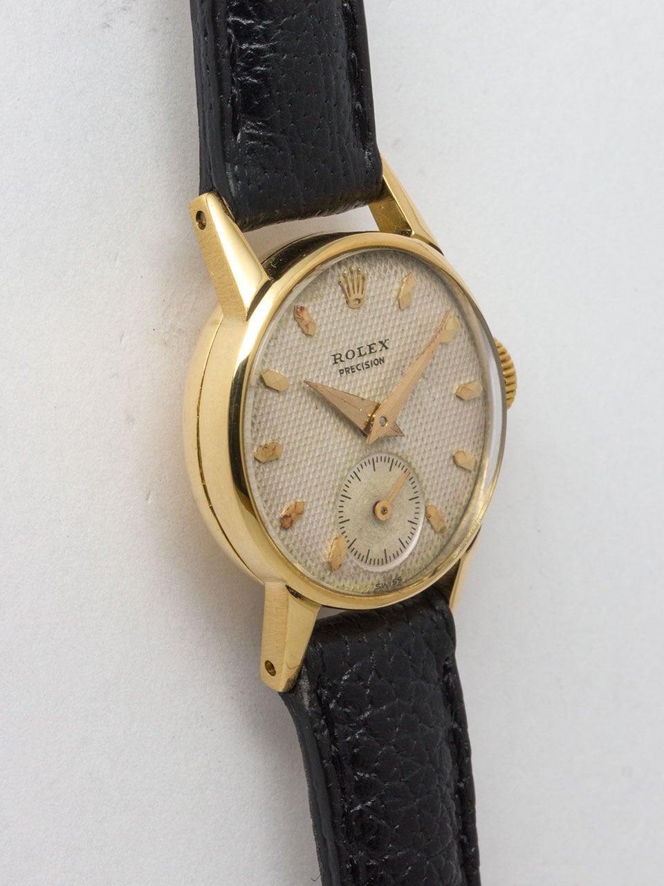 Rolex 18K Yellow Gold Lady's Precision Wristwatch ref 4779 circa 1953. 20 x 27mm snap back case with extended lugs. Original lightly patina'd textured dial with applied gold markers and tapered sword hands. Powered by 17 jewel manual wind movement