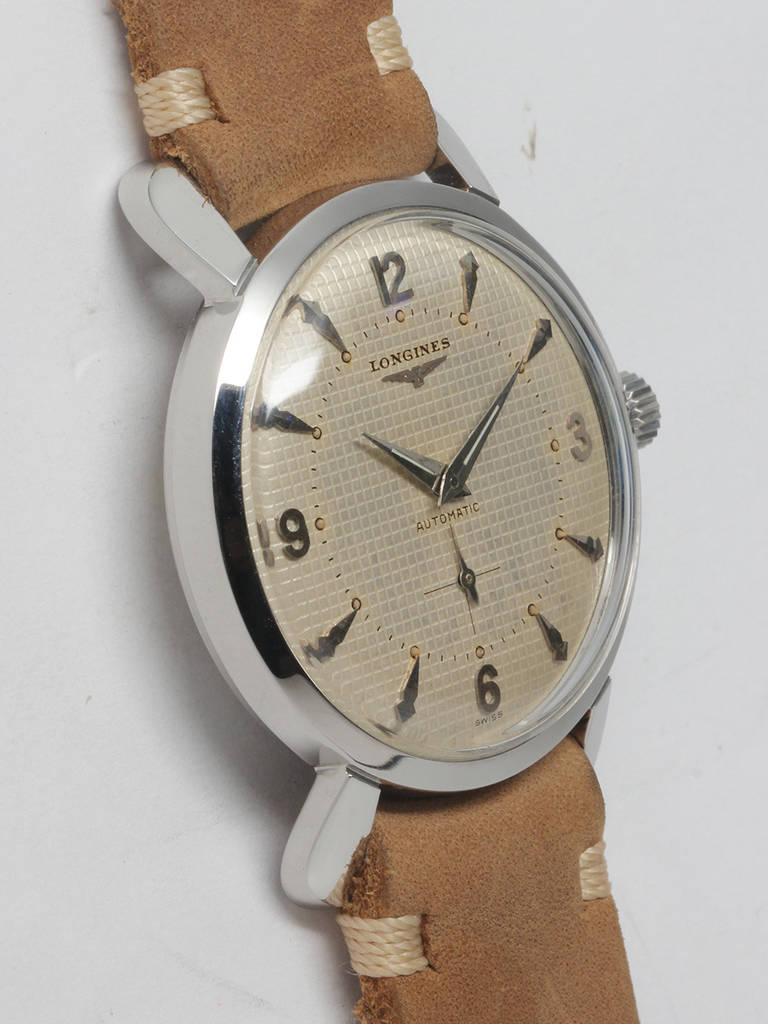 Longines stainless steel automatic wristwatch, circa late 1950s. 34 X 40mm screw back case with large rabbit-ear lugs, acrylic crystal and signed crown. Gorgeous patinaed matte silvered waffle dial with applied indexes, luminous dots and dauphine