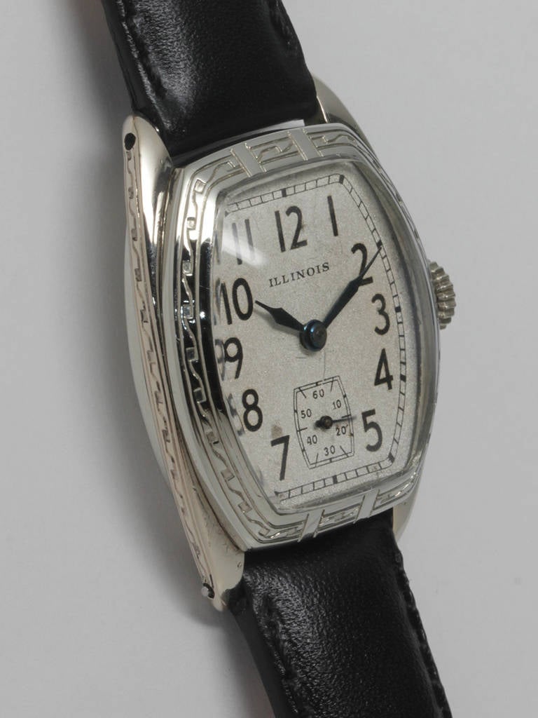 Illinois White Gold-Filled Beau Geste tonneau wristwatch with engraved bezel and sides, circa 1929. With original snowflake dial with black printed figures and blued steel hands. 33mm by 38mm watch case. 17-jewel manual-wind movement with subsidiary