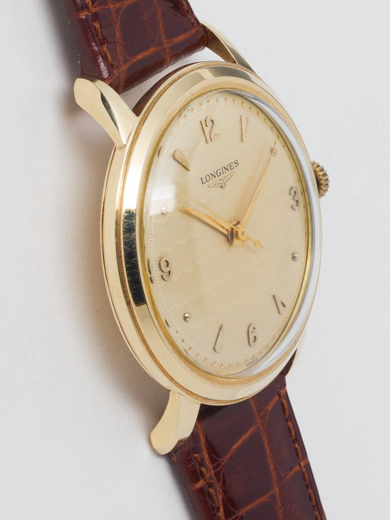 Longines 14k yellow gold dress model wristwatch, circa 1950s. Oversized 37 X 43 case with wide bezel and extended lugs with beautiful original guilloche dial in fine wave pattern with applied gold indexes, gold pearl minute indexes and tapered gold