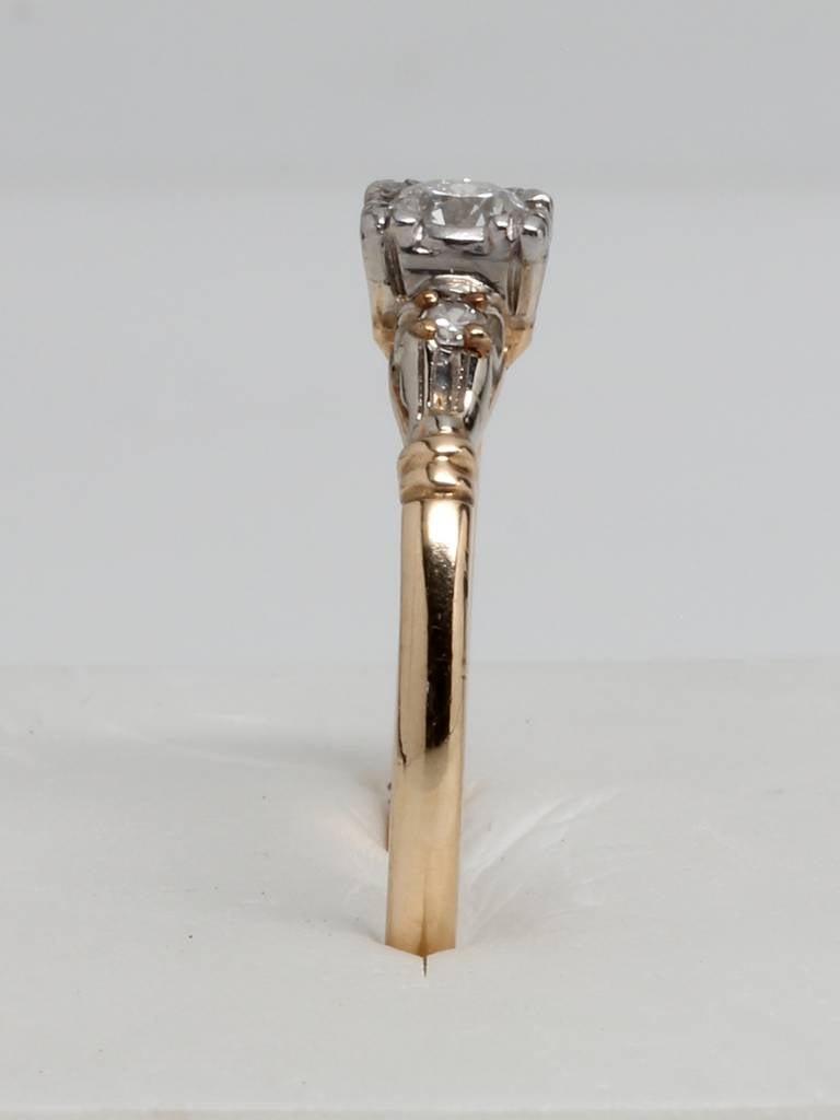 1940's solitaire setting with old European cut diamond, 0.20 carat, H color and VS1 clarity. Set in 14K yellow gold with 2 diamond melee side stones. Size 7.75

As a special offering for our 1stdibs customers, your purchase will arrive in one of