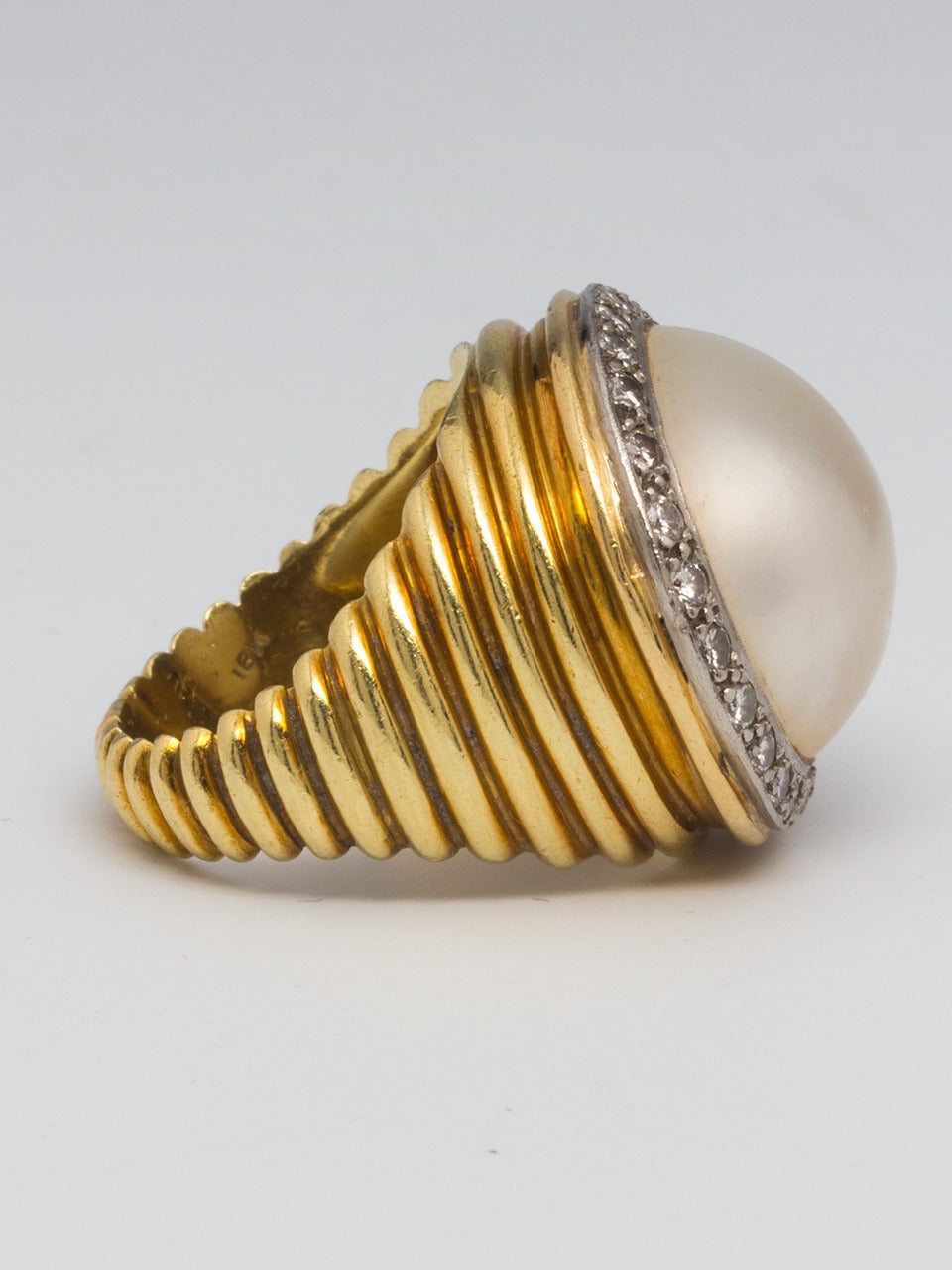 Fluted 18k yellow gold setting with a lustrous creamy color 18mm mabe pearl surrounded by 24 diamonds approximately 0.72 carat total weight, circa 1960's. Big, bold and fun cocktail ring. 7.25 ring size. 

As a special offering for our 1stdibs