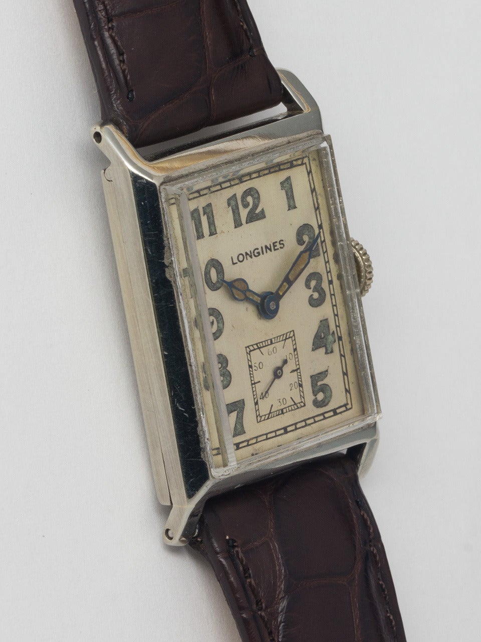 Longines 18K White Gold Rectangular Wristwatch, circa 1930. Hinged case measuring 24 X 36mm. Original matte silvered dial with luminous Arabic indexes and hands. Longines 10.86N 15-jewel manual-wind movement. Early large classic rectangular