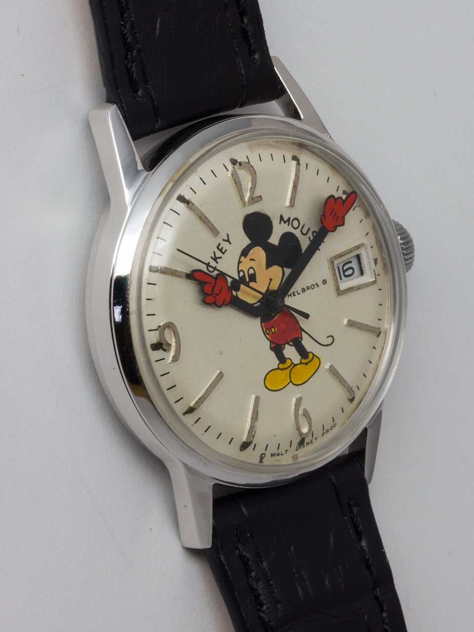 Adult-size Helbros stainless steel Mickey Mouse wristwatch, circa 1970s . 34 X 40mm screw-back case with acrylic crystal. Silvered satin dial with raised numbers, colorful image of Mickey with animated red gloved hands and date. Powered by a