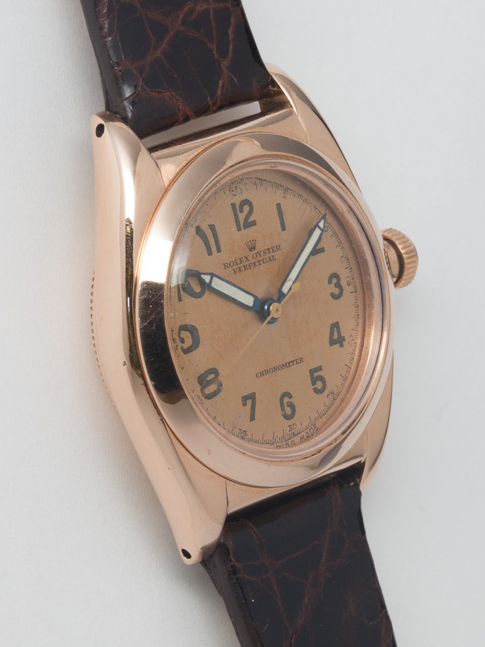 Rolex 14K Rose Gold Bubbleback Wristwatch, Ref. 3131 serial number 3.2 million, circa 1945. 32mm tonneau Oyster case and period rose gold bubble back crown. Original matte salmon dial with luminous indexes and hands. Powered by a self-winding