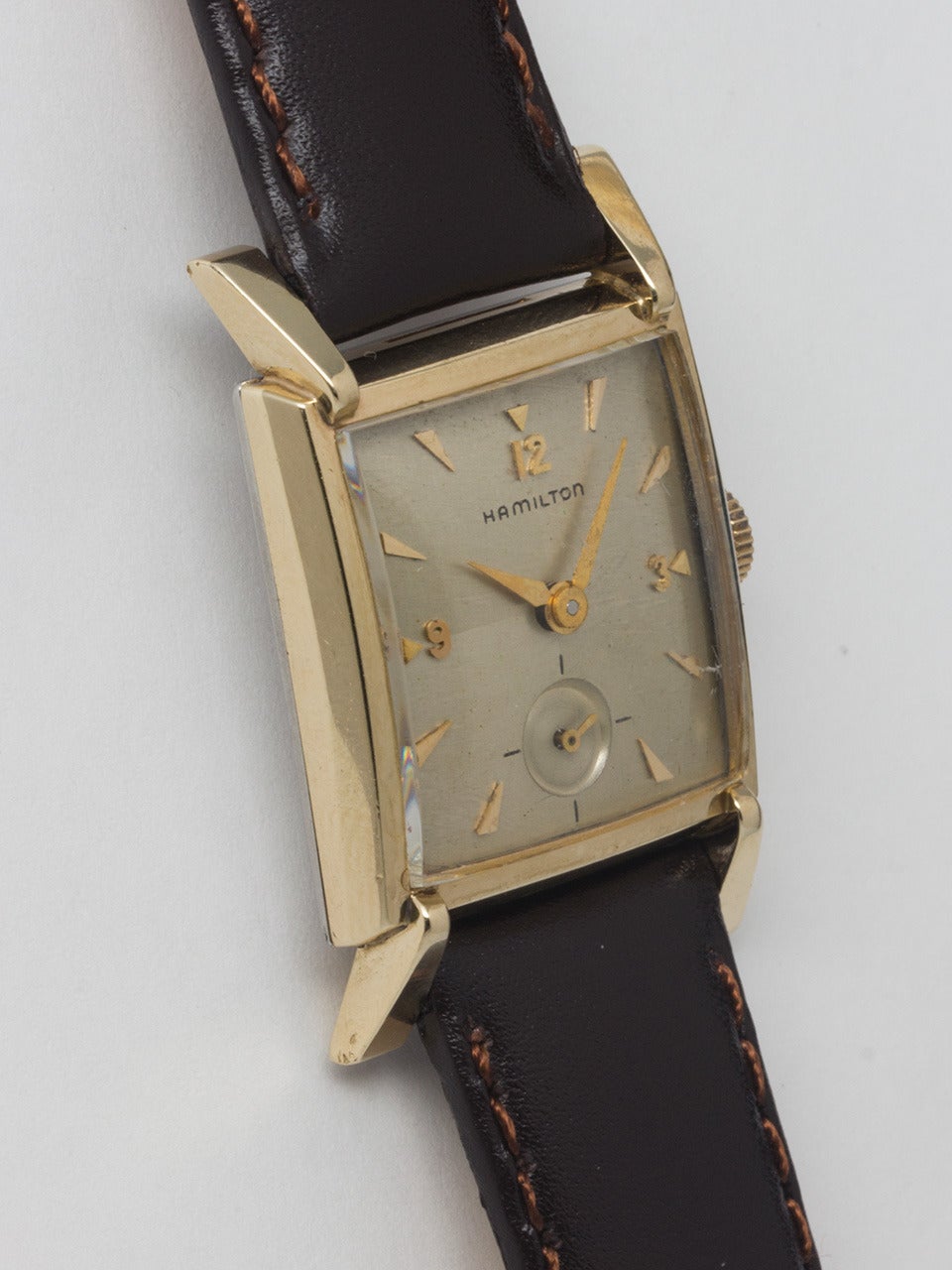 Hamillton yellow gold-filled wristwatch, Romanesque S mode, circa 1950s. Short rectangular case with extended flared lugs measuring 24 x 36.75mm. Original silvered satin dial with applied indexes and alpha hands. Powered by a 17-jewel manual-wind