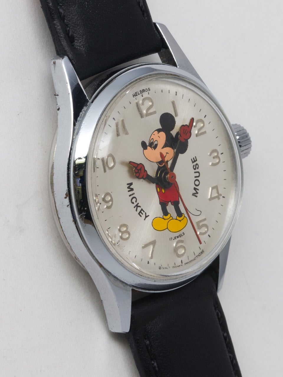 Helbros Mickey Mouse wristwatch, circa 1960s. Midsize 30 x 37.5mm base metal chromium plated case. With silvered dial with raised numbers and colorful image of Mickey with animated red gloved hands. Powered by a 17-jewel manual-wind movement with