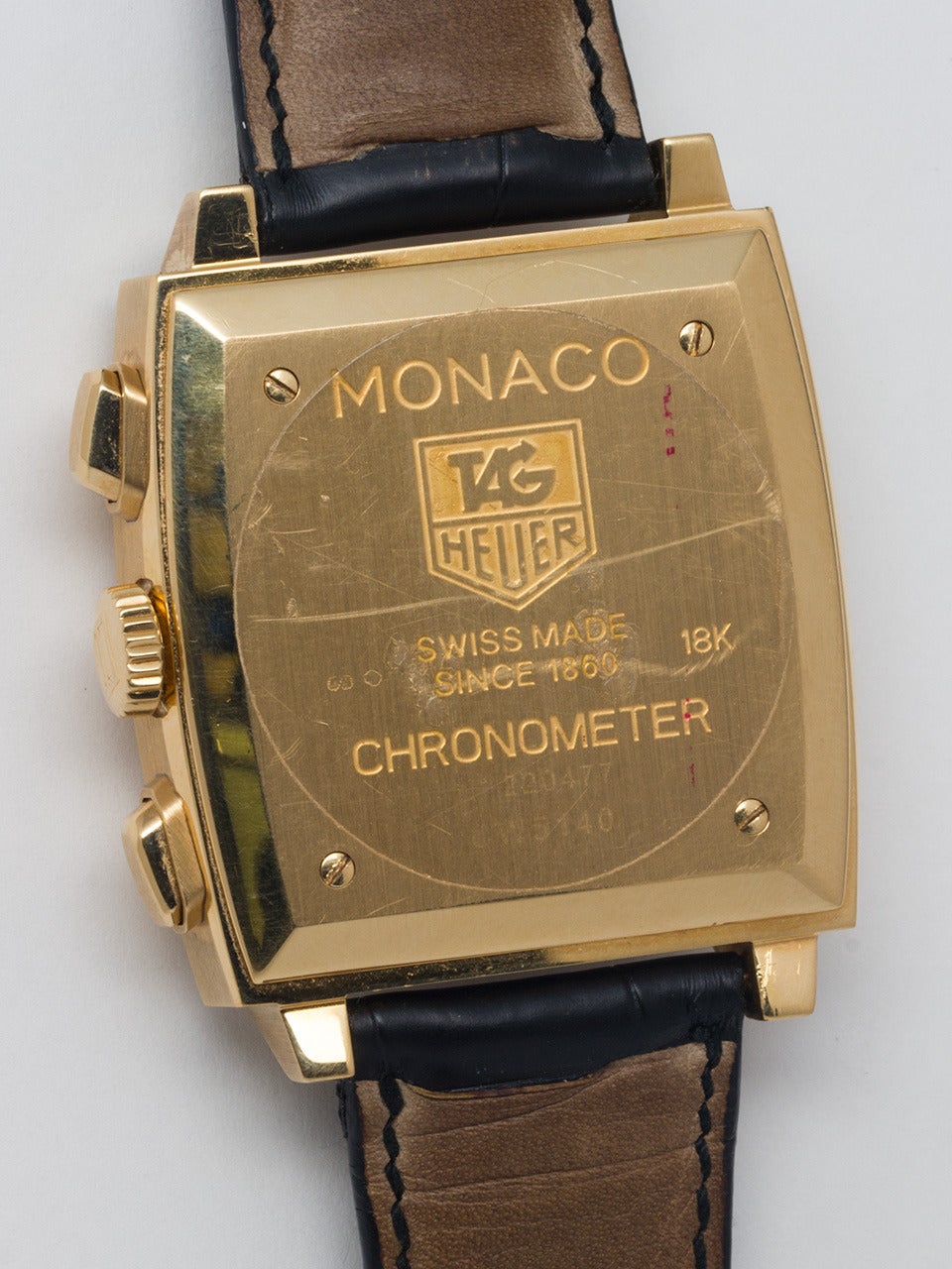 TAG Heuer 18K Yellow Gold Monaco Reissue Chronograph Wristwatch, circa 2010. Oversized 38mm square case with solid case back secured by screws with original clear sticker. Original silvered satin dial with applied gold indexes and gold luminous