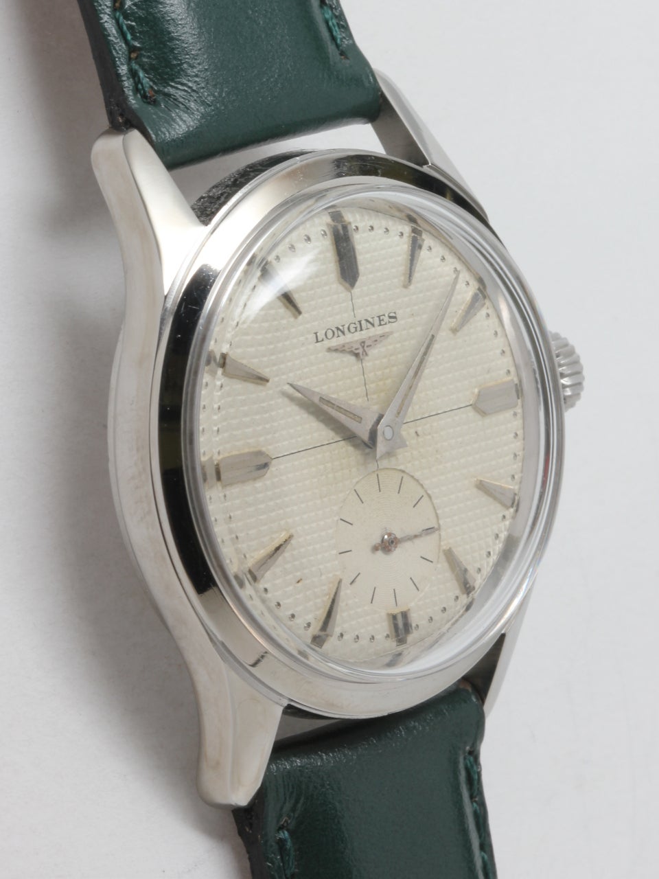 Longines Stainless Steel Wristwatch, circa 1950s. 28 x 34mm case with screw back and extended lugs. Very pleasing original textured silvered dial with applied indexes and dauphine hands. 17-jewel manual-wind movement with subsidiary seconds.