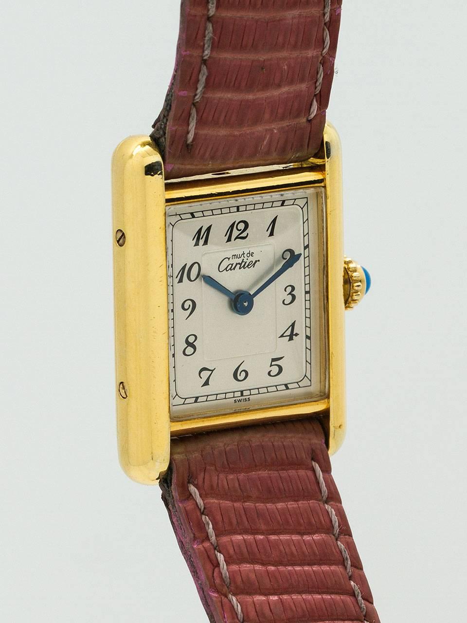 Cartier Lady’s Vermeil Tank Louis circa 1970s. 21 x 27mm case secured by 4 side and 4 case back screws. With unusual silvered dial signed Must de Cartier and with black printed Arabic figures, with blued steel hands, and blue cabochon sapphire