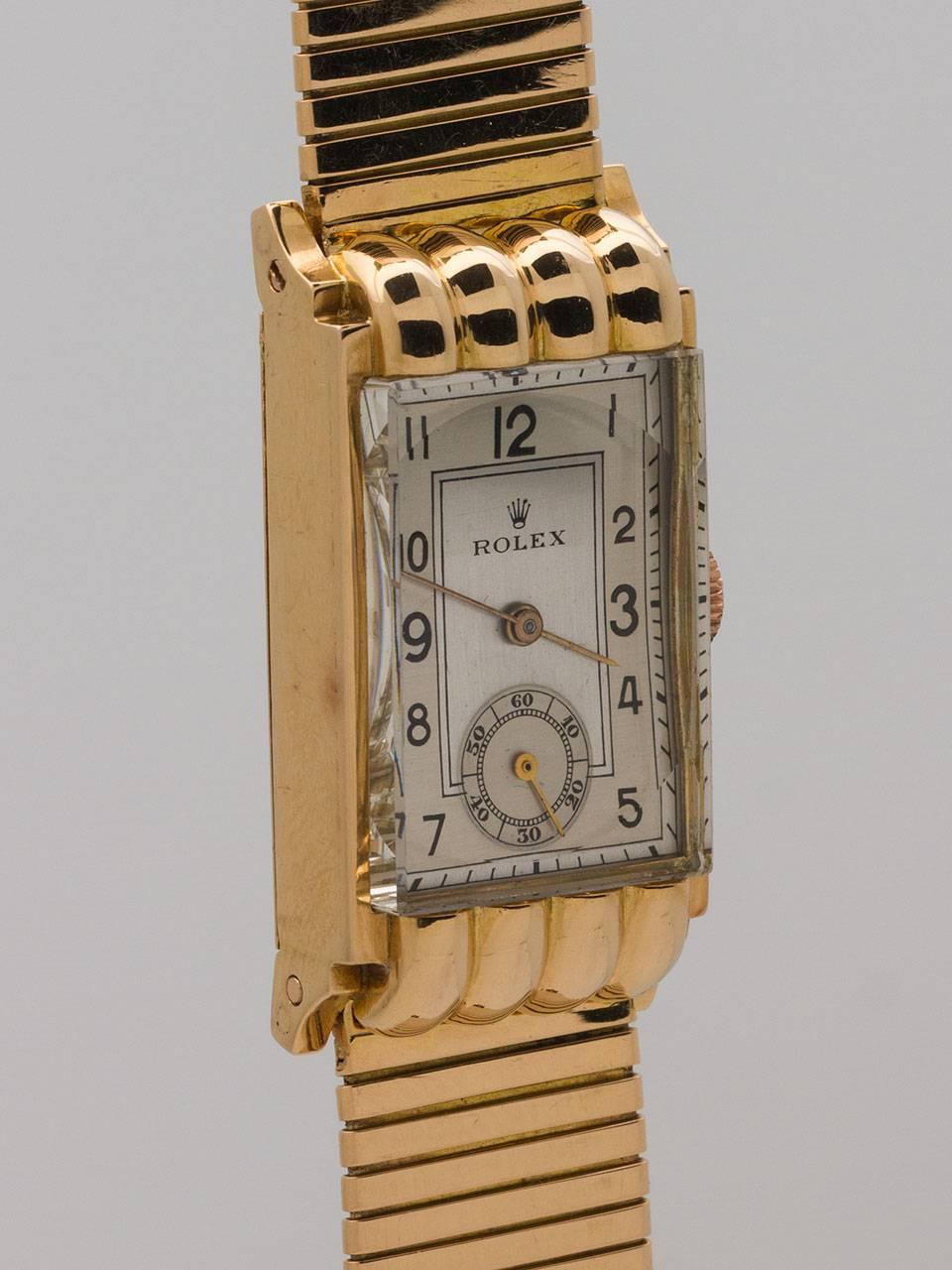 Rolex 18K Yellow Gold dress model featuring highly stylized French made case circa post war 1940’s. Featuring 19 x 38mm case with fluted hooded lug design and squared glass crystal. Beautifully restored silvered satin dial with black Arabic numerals