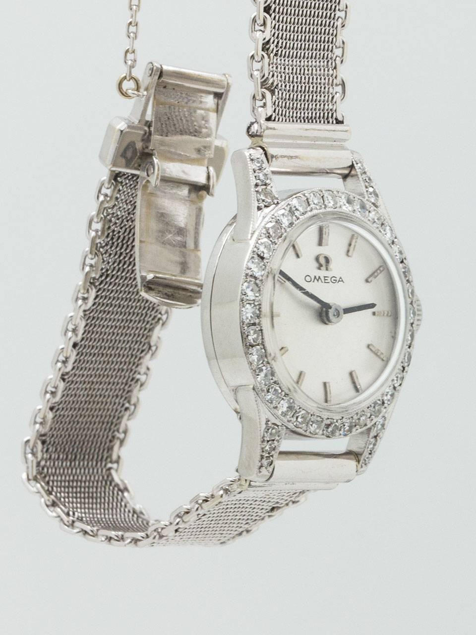 Omega Platinum and Diamond Dress Wristwatch circa 1950’s.  Petite and very pretty design 19 x 25mm round case with extended lugs all pave set with single cut diamonds. Very pleasing silver satin dial with raised silver indexes and silver baton