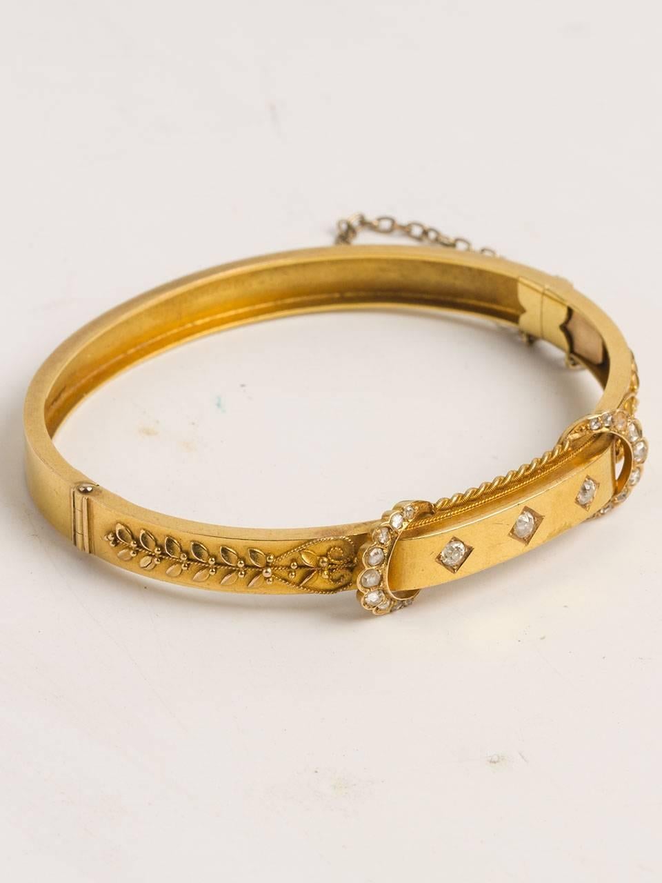 Victorian 15K yellow gold diamond hinged bangle bracelet. With applied floral details accented by finely twisted wire and 18 rose cut diamonds set in crescent shapes. 3 old mine cut diamonds sit across the top in separate little oblique squares.