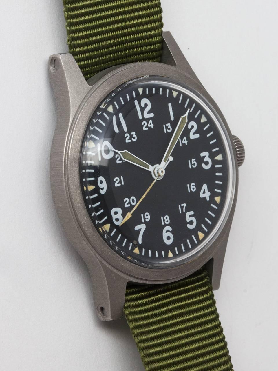 Hamilton US Military Issue Wristwatch c. 1982. Featuring 34 X 41mm non reflective brushed finish base metal case and acrylic crystal. Original matte black dial with 24 hour indexes and triangular luminous hour indexes, luminous hands and arrow