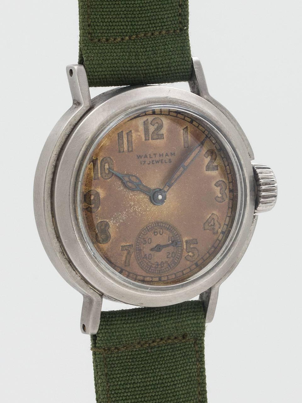 Waltham Premier U.S. Military WWII Era Wristwatch. Brushed metal non reflective case with distinctive design, measuring 33 x 37mm. Fantastic patina’d original dial with printed Arabic numeral luminous and hands. Powered by manual wind 17 jewels