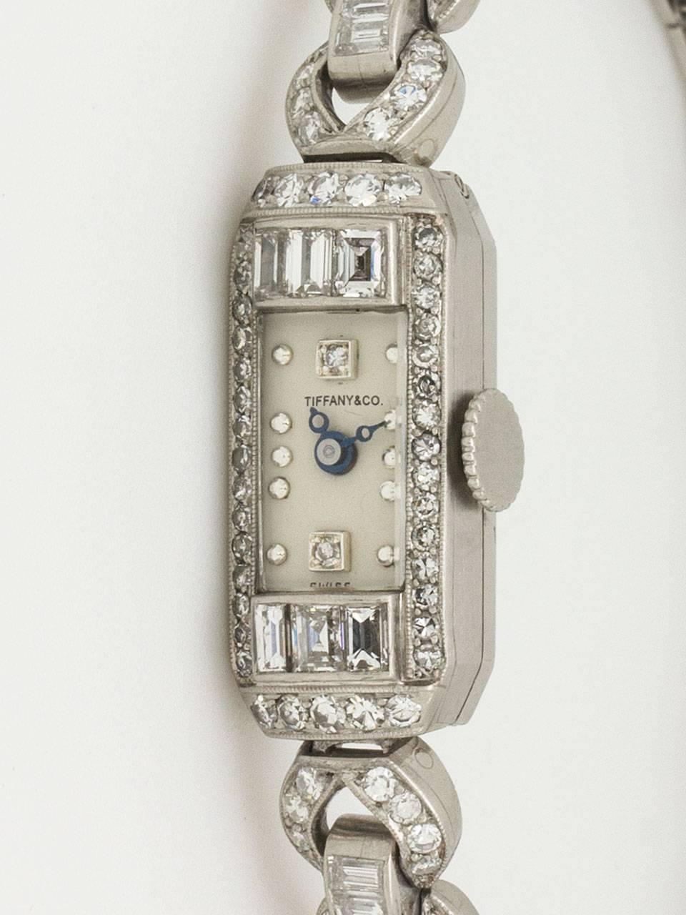 Tiffany & Co. Platinum and Diamond Art Deco Lady's Dress Wristwatch circa 1930s. Featuring an elegant 11 x 24mm baguette shaped case set with 3 upper and 3 lower baguette shaped diamonds, surrounded above and below with a total of 40 round single