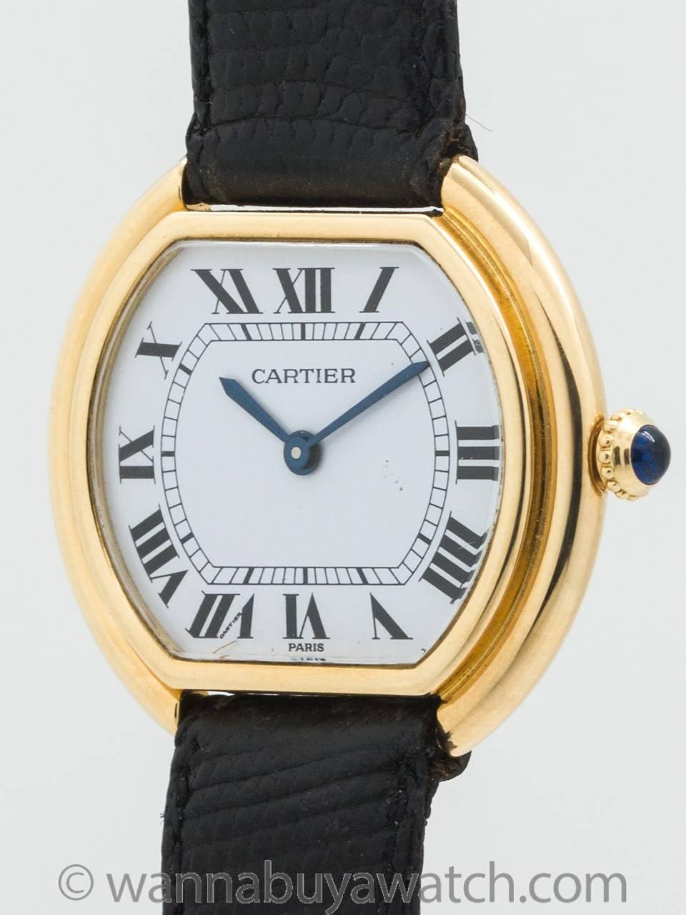 Vintage Cartier man’s “Ceinture” 18K yellow gold tonneau shaped 32 X 30mm case with stepped, bowed sides, mineral  glass crystal, and original glossy white dial with black Roman figures and blued steel hands. Powered by 17 jewel manual wind movement