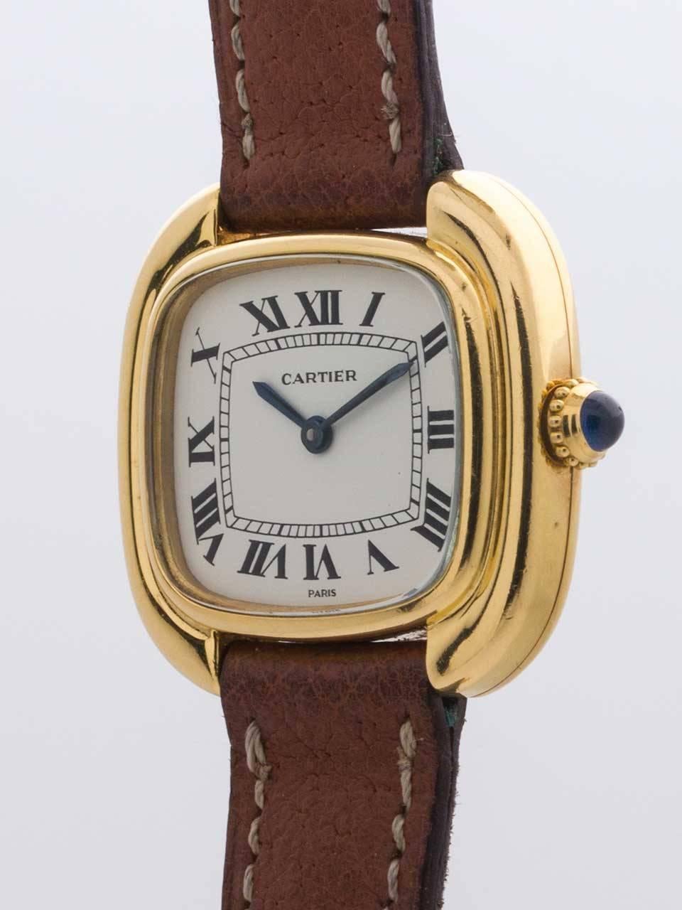 Cartier Lady’s Gondole 18K Yellow Gold circa 1970s. 27 x 25mm stepped case with blue sapphire cabachon crown. White dial with printed black Arabic numerals and blue steeled hands. Powered by battery quartz movement. On short brown leather signed