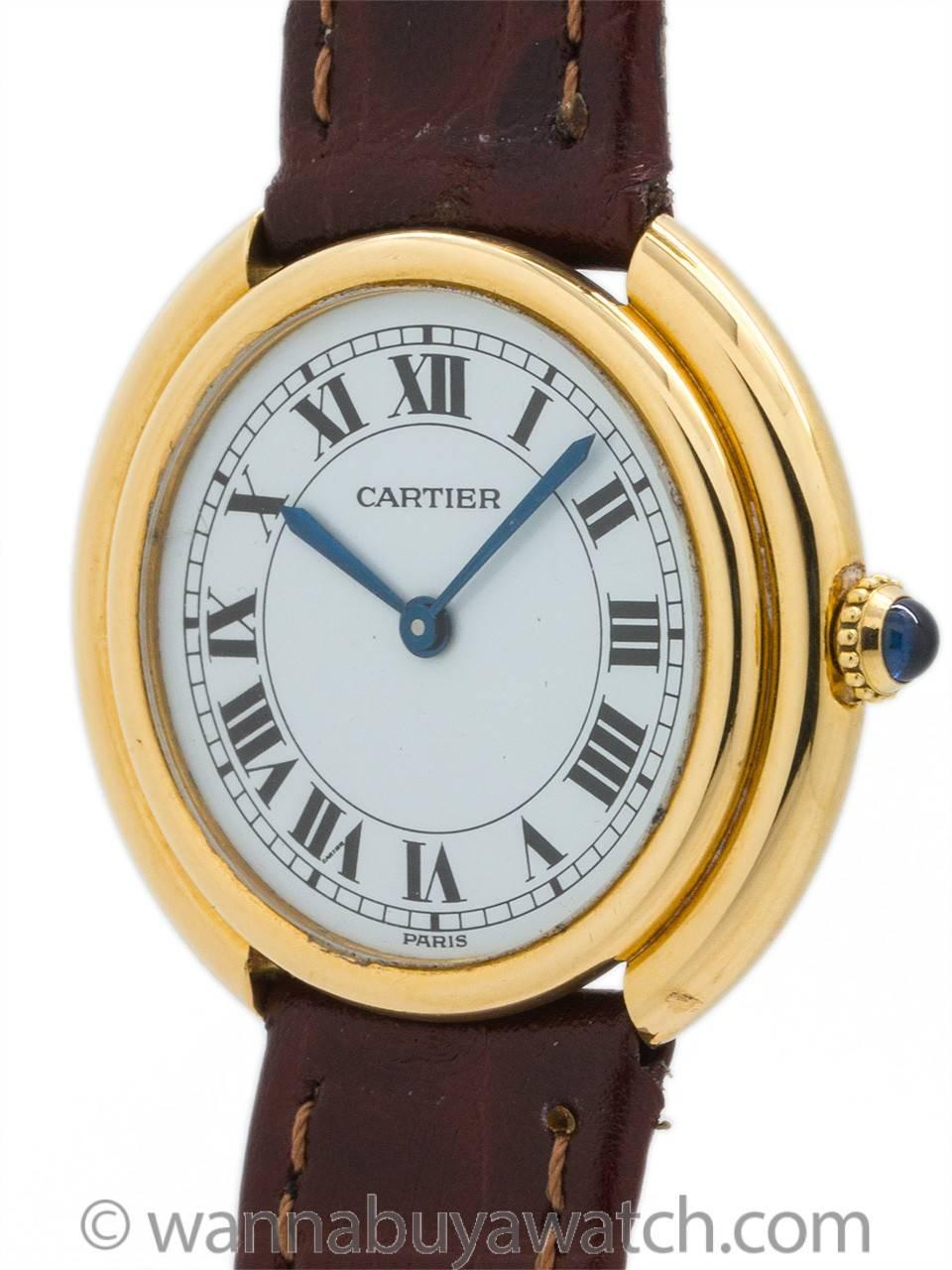 Cartier Tank 18K Gold “Vendome” circa 1980’s. Man’s 33 x 32mm round case with rounded stepped case design. Featuring white gloss dial with classic Cartier Roman figures, blued steel hands, and powered by 17 jewel manual wind movement with cabochon