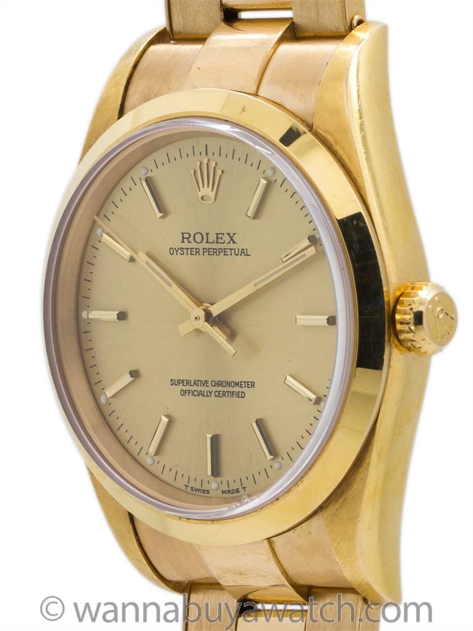 Great looking Rolex Oyster Perpetual 18K gold ref 14208 circa 1997. Featuring 34mm diameter case with smooth bezel and sapphire crystal and original champagne dial with applied gold indexes and gilt baton hands. Powered by self winding calibre 3135