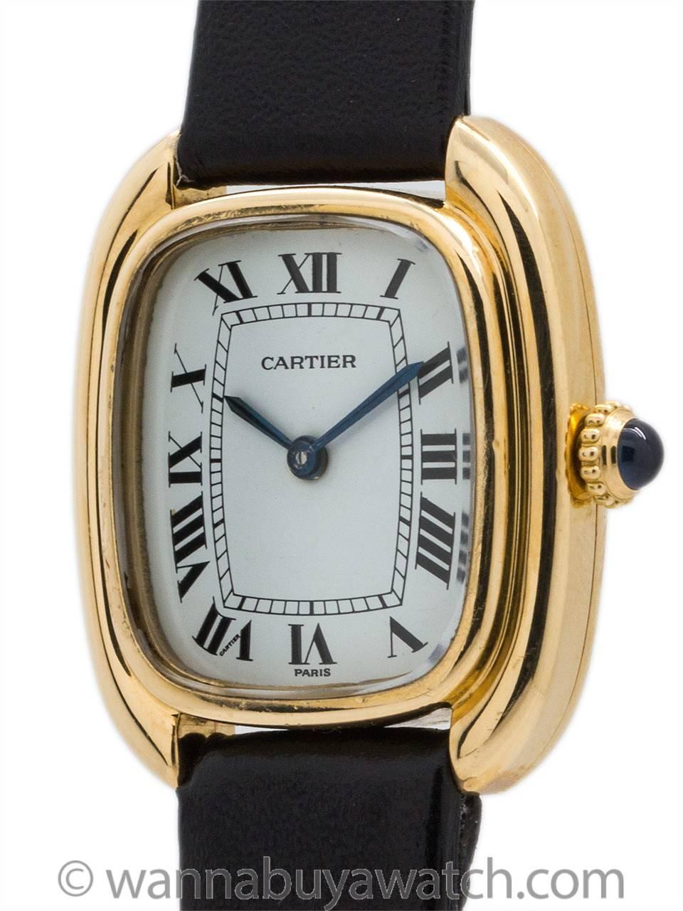 Cartier 18K gold lady's Gondole model circa 1973. Scarce and great looking elongated cushion shaped case with rounded and wide stepped bezel. With mineral glass crystal and original classic glossy white Cartier dial with Roman figures and blued