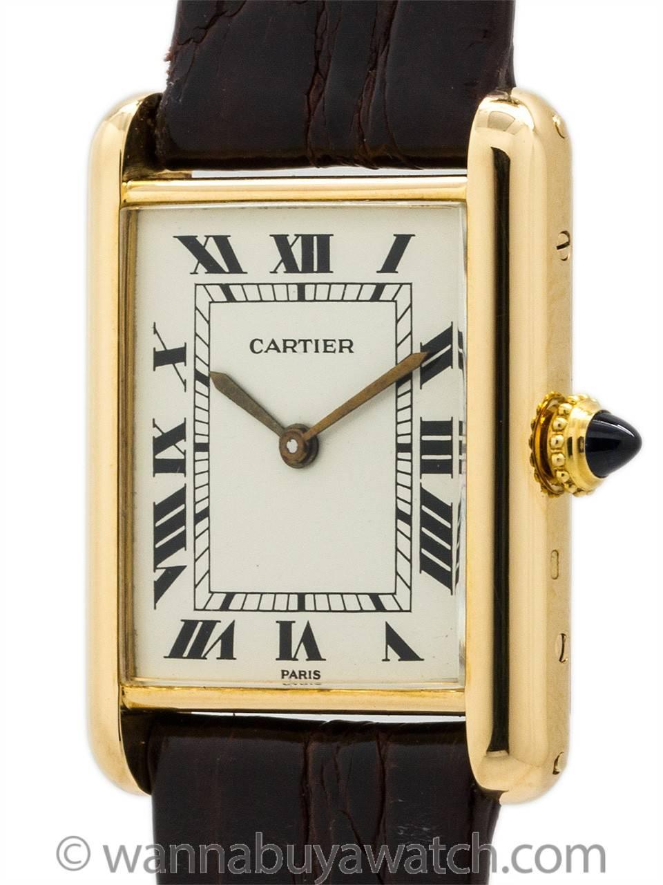 Cartier Tank Louis man’s size 18K YG circa 1970’s with classic white dial and Roman figures, gilted hands, 17 jewel manual wind Cartier signed movement and cabochon sapphire crown. Featuring  man’s small size 23.5 X 31mm case secured by 4 side
