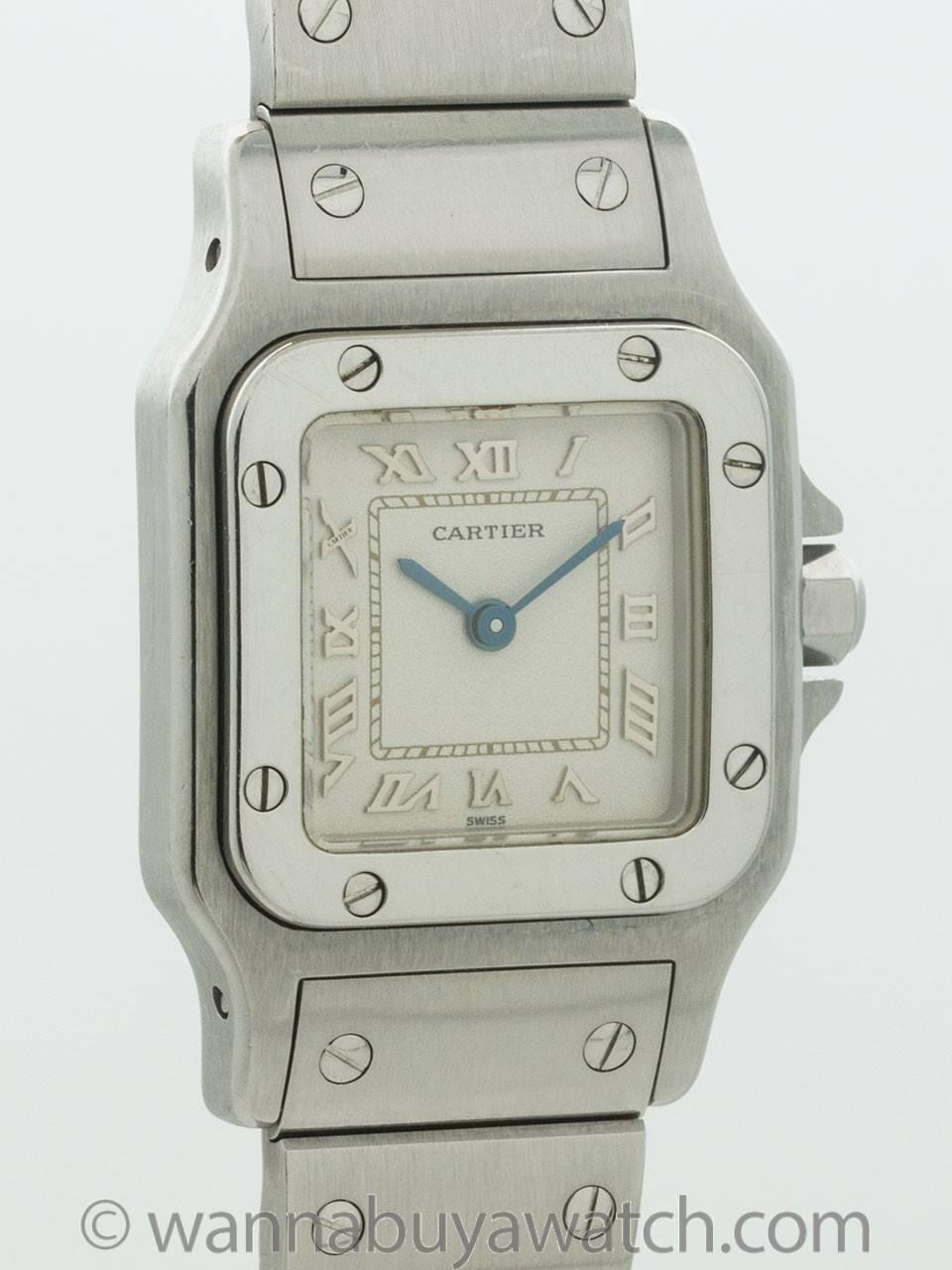Cartier Stainless Steel Lady’s Santos ref 1565 circa 2000s. Square case measuring 24 x 35mm with rounded corners, screwed down bezel and cabochon sapphire crown. Classic Cartier white dial with applied Roman numerals and blue steeled hands. With