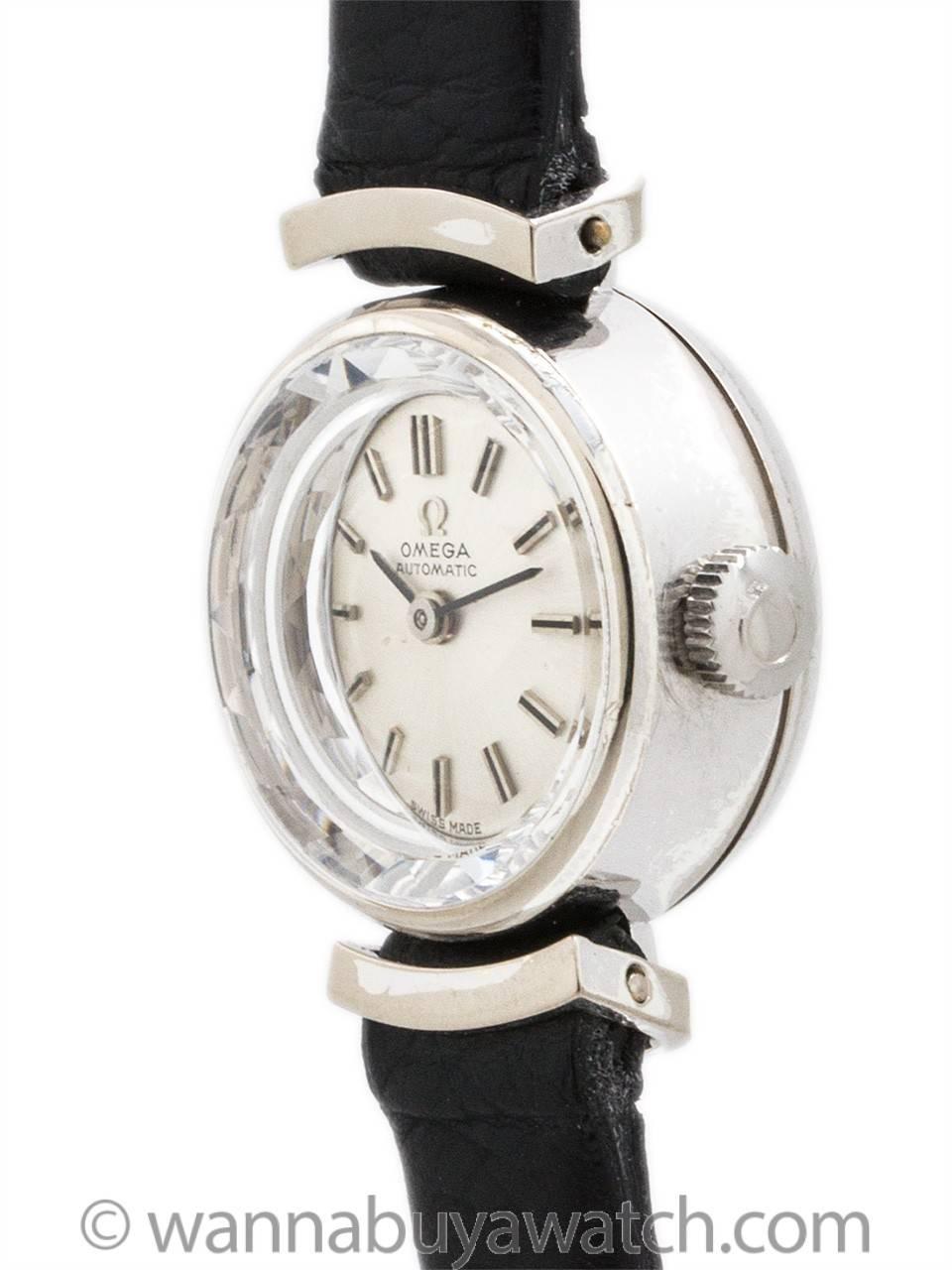 Lady Omega 14K white gold dress model circa 1960’s. Featuring 18 X 24mm case with very attractive case design with “floating” curved lugs matching shaped of case. With diamond cut glass crystal, original silver satin dial with applied silver