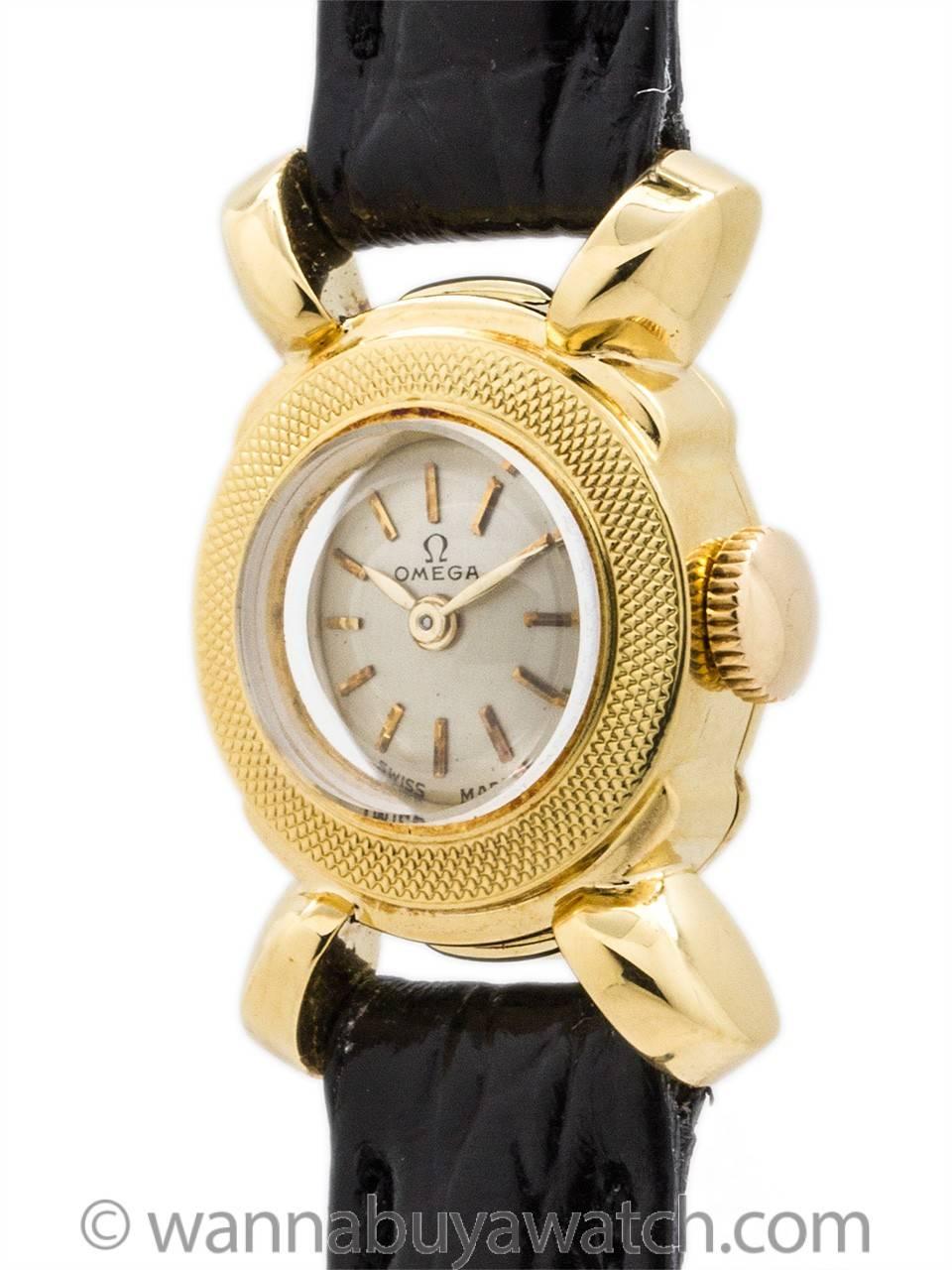 lady Omega manual wind dress watch circa 146. Featuring 15 x 23mm 18K YG case with finely hammered textured bezel, large lobed “ship’s wheel” lugs, original silvered satin dial with applied gold indexes and gilt baton hands. Powered by 17 jewel