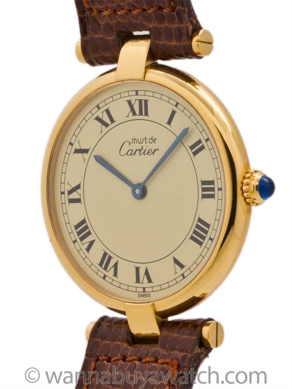 Cartier man’s vermeil Vendome Tank wristwatch circa 1990s. Featuring a round thin case measuring 30.5 x 37mm with T-bar lugs. Featuring original cream dial with classic printed Cartier Roman numbers with blued steel hands and blue sapphire cabochon