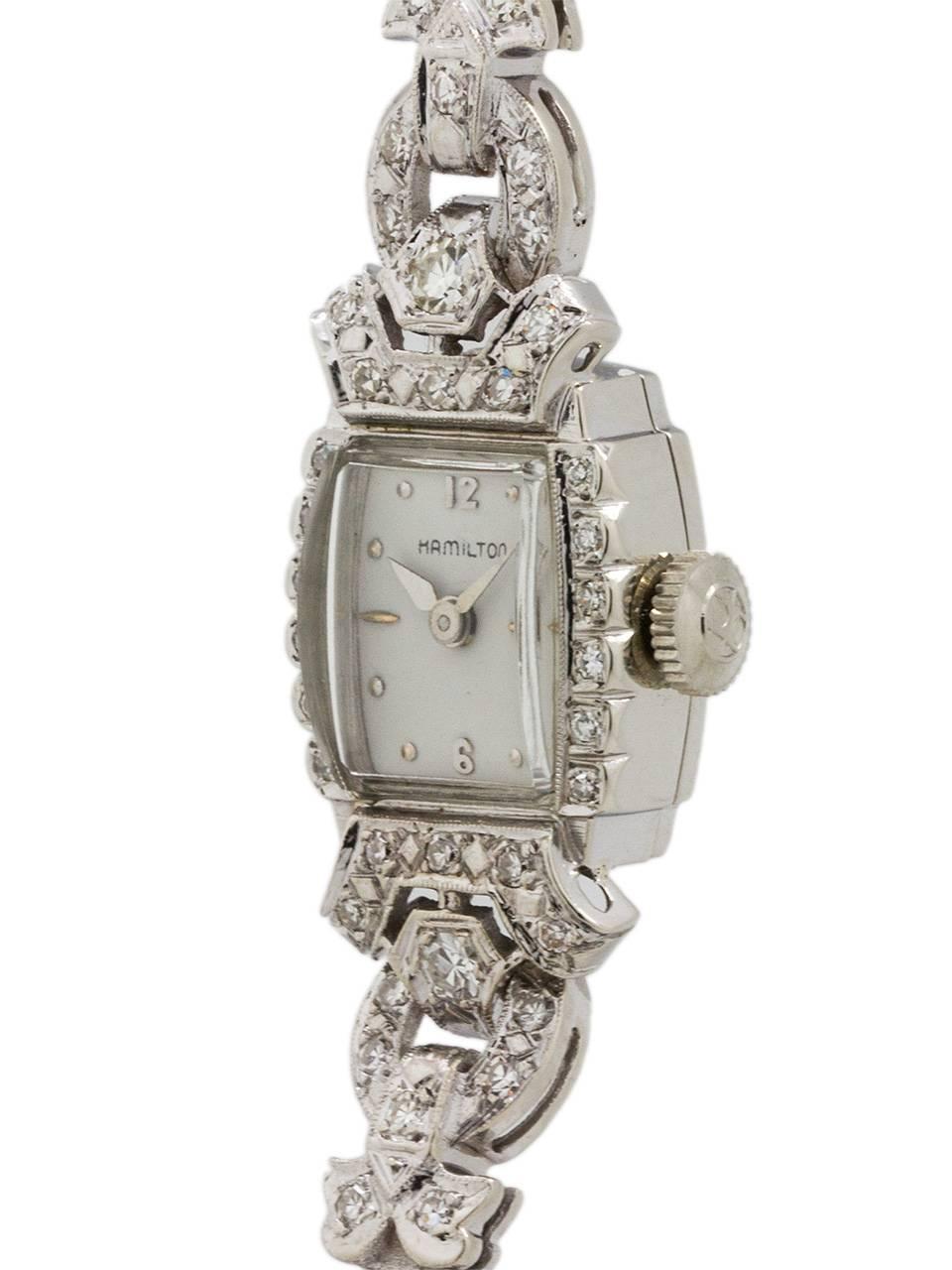 Vintage Lady Hamilton Platinum & Diamond Set Watch circa 1950's. Featuring a tonneau shaped case with hinged bracelet attachment beautifully decorated in a garland design with 2+ carats of diamonds including a prominent round brilliant cut diamond