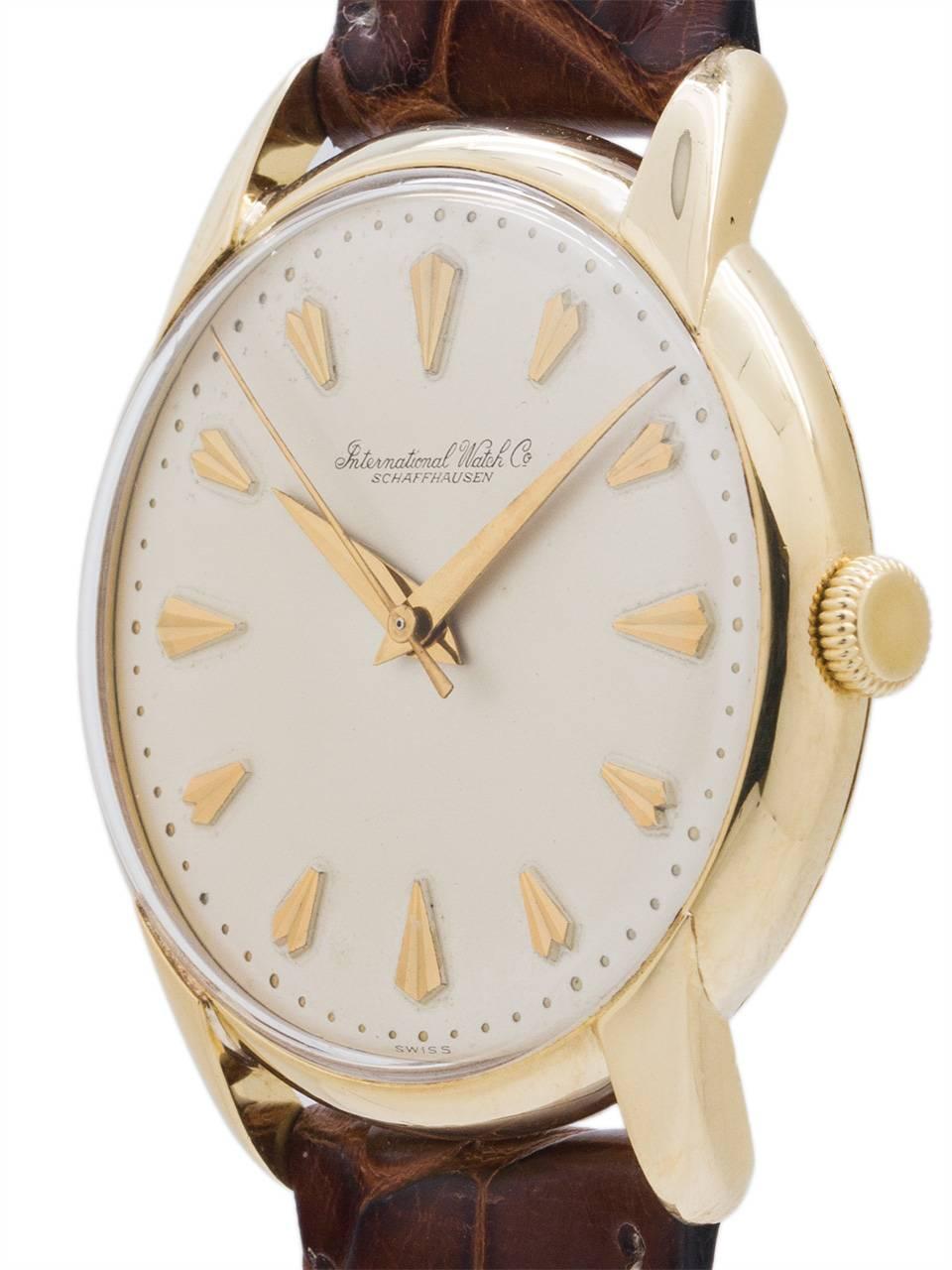 A very attractive IWC 18K YG dress model circa 1958 featuring 35 X 40mm heavy snap back case with extended horn lugs, acrylic crystal, and original very pleasing matte silvered dial with stylized fan shaped gold indexes, subtle gold pearl seconds