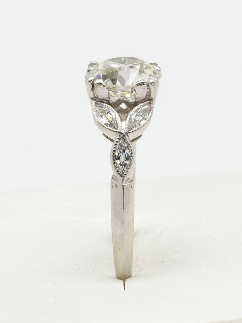 Gorgeous vintage platinum engagement ring featuring a stunning 1.29 carat Old European Cut J/SI1 center diamond flanked by whimsical floral motifs set with three marquise side stones on each side. Top of ring measures 7mm, tapering to a 1mm narrow