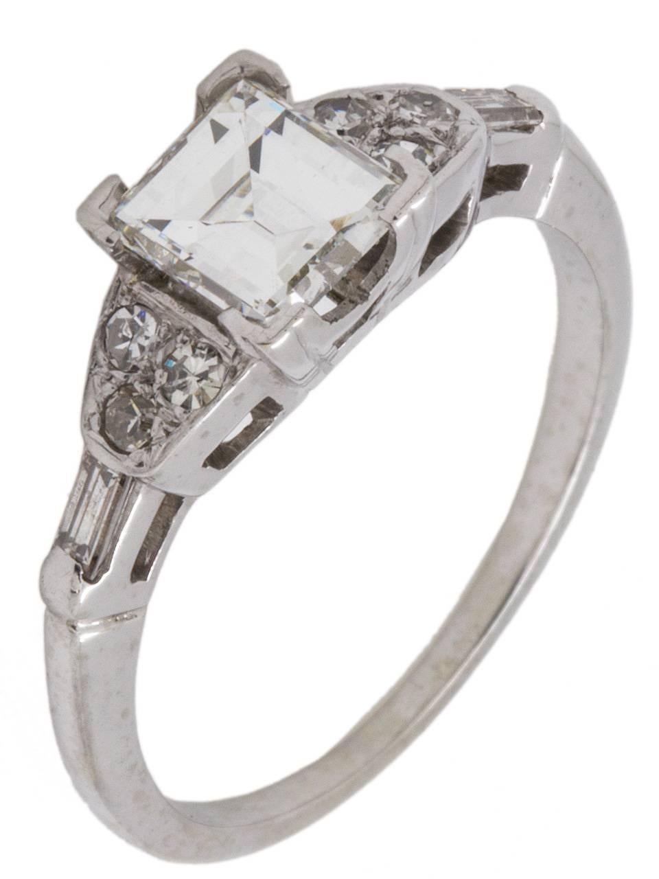 Gorgeous 14K white gold diamond engagement ring set with a very bright and lively EGL certified 1.02 carat step cut center stone, H /VS2, flanked by two bar-set baguettes and six round single cut diamonds set in a floral motif which weigh