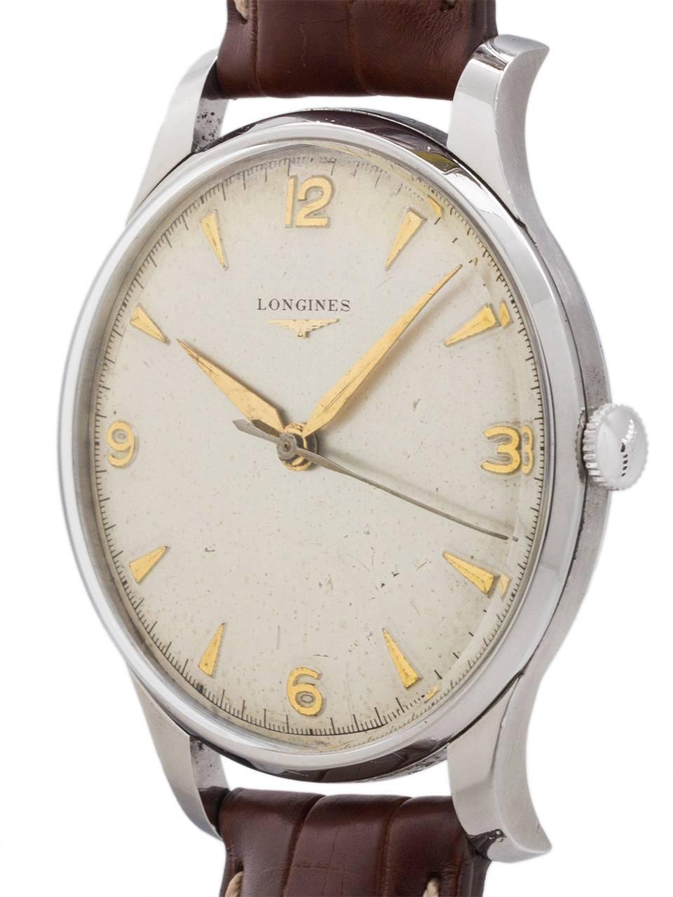 Vintage man’s Longines stainless steel oversize manual wind dress model circa 1956. Featuring large for the era 37 x 46mm heavy snap back case with extended lugs, acrylic crystal, matte silvered dial with raised gold tapered indexes and tapered gilt
