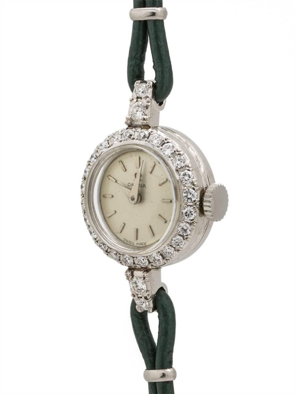 Vintage lady Omega  platinum case dress watch set with diamonds circa 1954. Featuring a 17mm round case with center cord attachment, with bezel and lugs set with diamonds, with glass crystal and silvered satin dial with applied silver indexes,