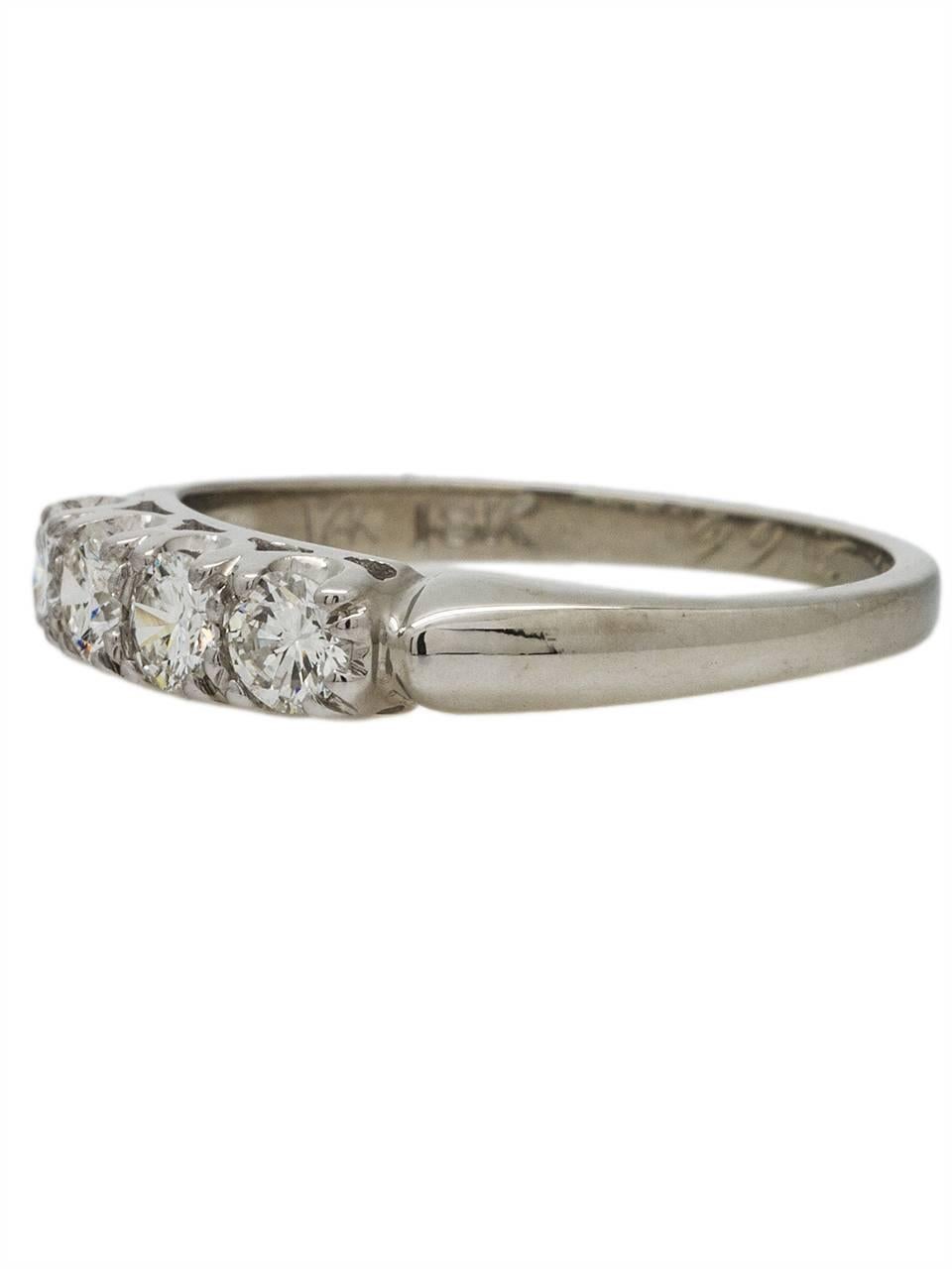 This substantial 18k white gold vintage diamond wedding band is set with 4 full cut modern round brilliant diamonds, total weight .60ct, G/VS2. Lovely bead set mounting with classic fish-tail scroll side galleries. Stands beautifully alone or paired