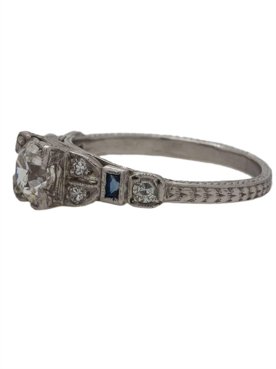 This intricately engraved engagement ring features an exquisitely cut 0.71ct Old European Cut diamond, H/VS2. Although this piece was recently manufactured in the 2000s, it was designed and crafted to look like an antique ring from the 1920s, and is