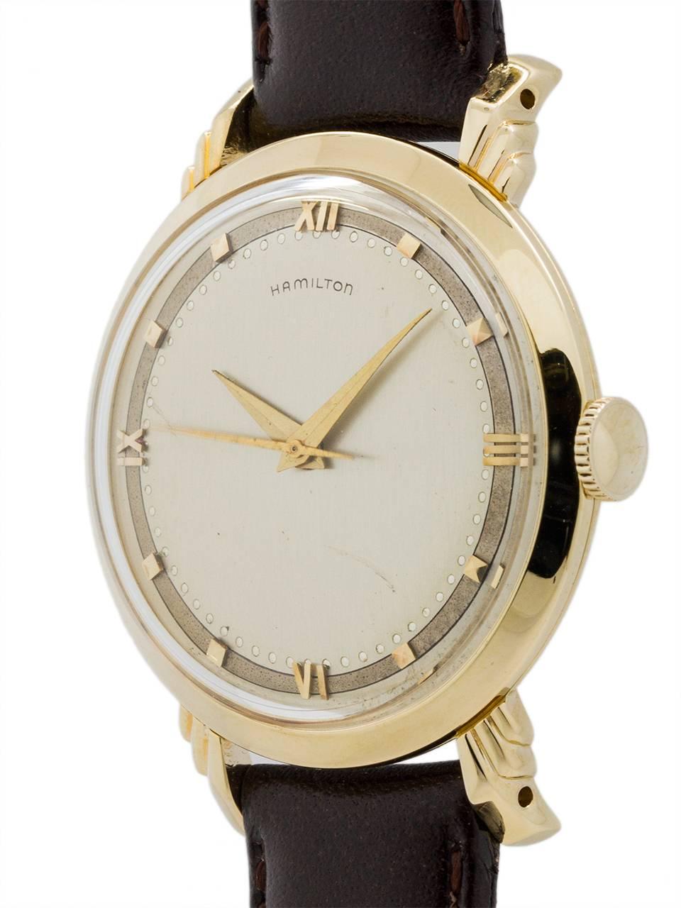 An unusually large for the era 14K YG man’s vintage Hamilton dress model circa 1953. Featuring 34 x 42mm case with “winged” design stepped lugs. With original beautiful condition 2 tone silver satin dial with 18K YG applied Roman figures and indexes