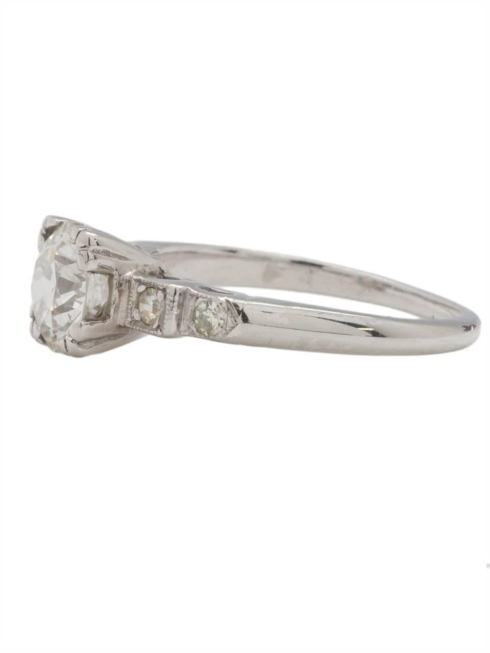 This classic vintage platinum engagement ring from the 1930s features a captivating 1.22 carat Old European Cut center diamond, J-VS1. Four petite bead set round side diamonds are the perfect accent to the center stone setting. Open side galleries
