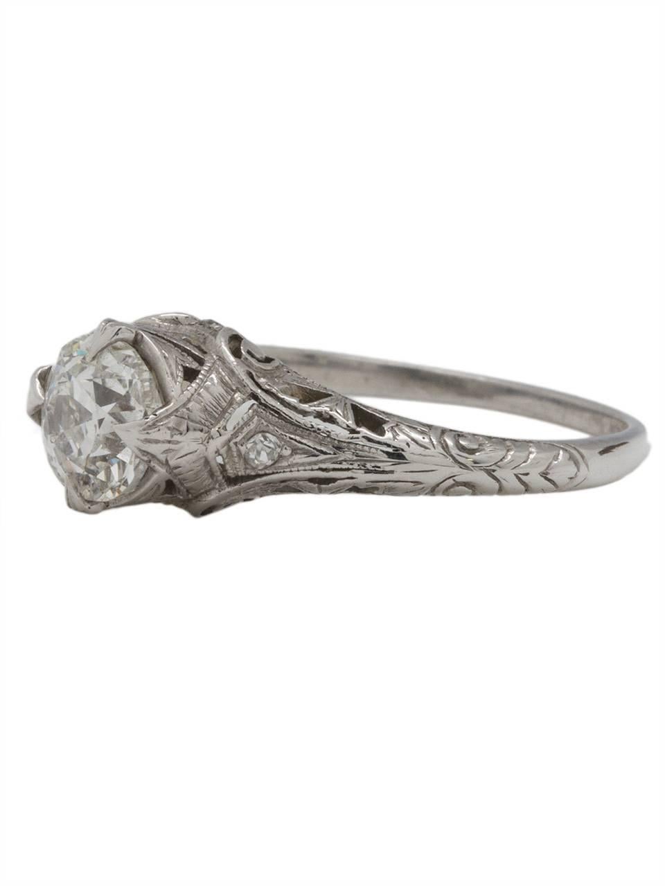 This lovely antique Edwardian platinum engagement ring showcases a stunning EGL certifed 1.10ct Old Mine Cut center diamond, G-SI2. This ring is loaded with romantic detail; softly swirling filigree and a delicate milgrain edge wrap up and around
