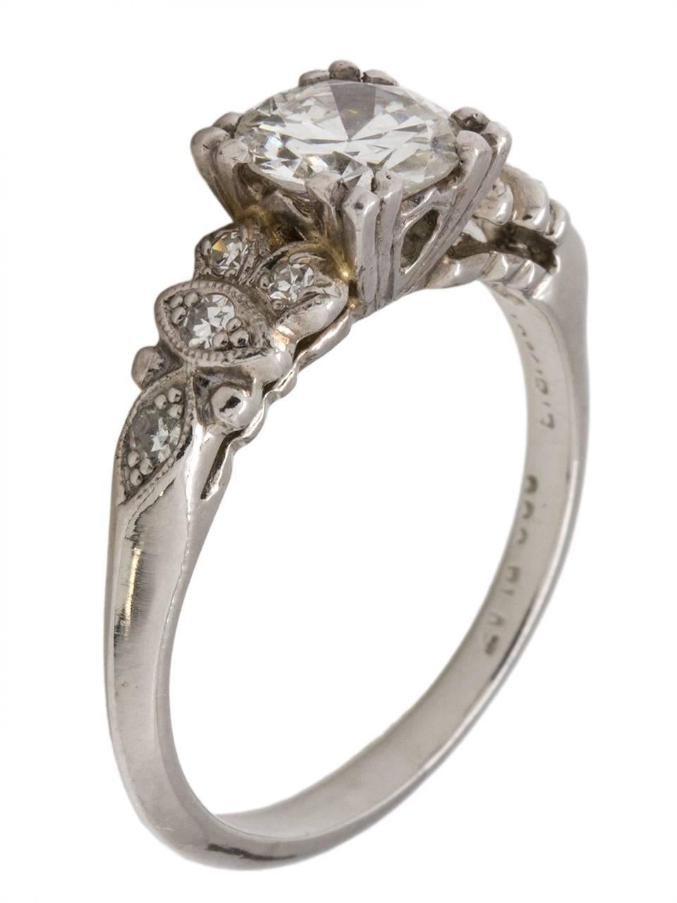 This beautiful 1930s platinum engagement ring stars a bright and fiery EGL certified  0.94ct Old European Cut center diamond, G-VS1. A whimsical marquise motif adorned with eight bead set round side diamonds are the perfect accent to the elevated