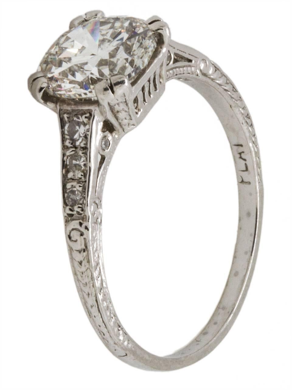 Wonderfully detailed "new vintage" platinum engagement ring starring an impressive 1.52ct round brilliant center diamond, H-SI2. Six bead set round side diamonds adorn the narrow, tapered shank. Beautifully executed engraving details