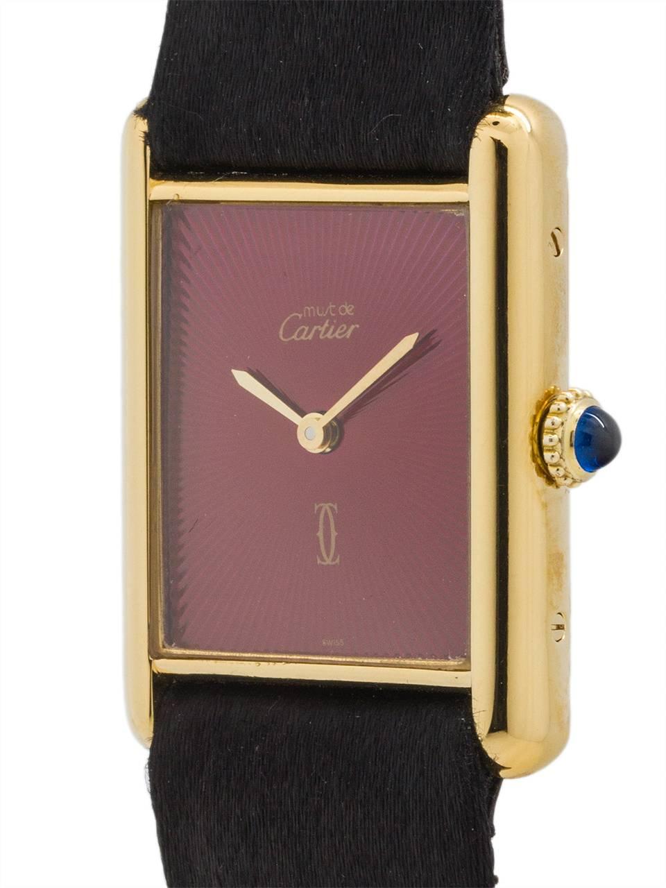 
Cartier Man’s Tank Louis circa 1990s. Featuring 24 x 30mm vermeil (20 microns gold over silver) case secured by 4 case back and side screws. Featuring a beautiful custom color dial in red/burgundy sunburst, signed Must de Cartier, and gold hands.