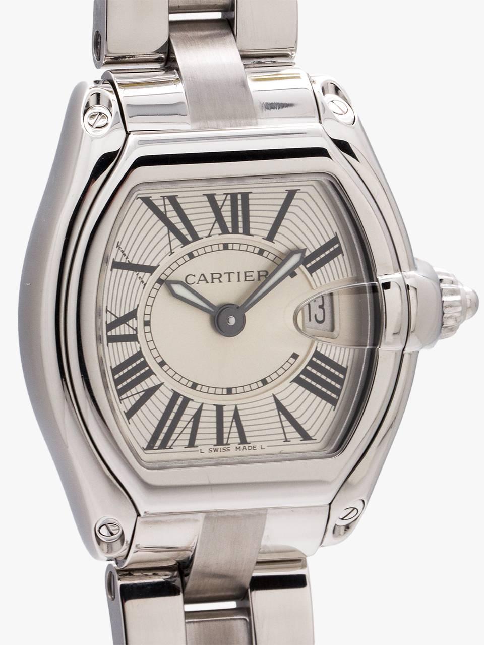 Cartier lady Roadster circa 2000’s. Featuring 31 x 37mm tonneau shaped case with sapphire crystal and date at 3 o’clock. With classic stretch Roman figures dial, with 2 tone silvered dial. Battery powered quartz movement. With luminous sword style